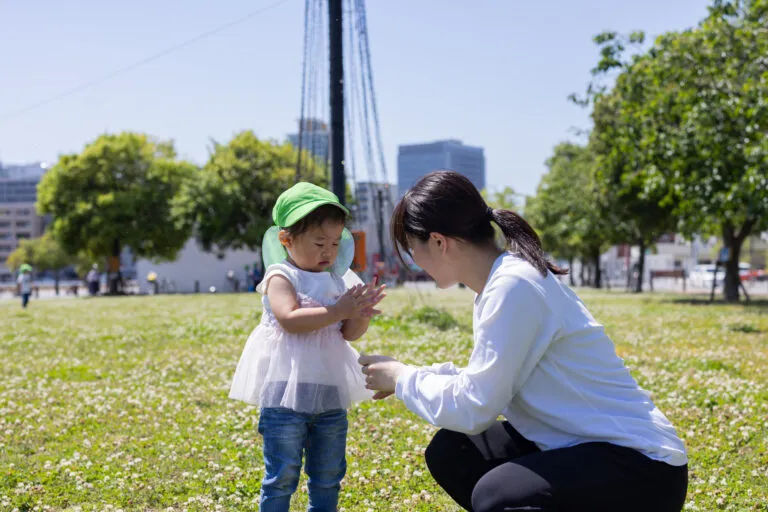 公園で子供と触れ合う女性の写真