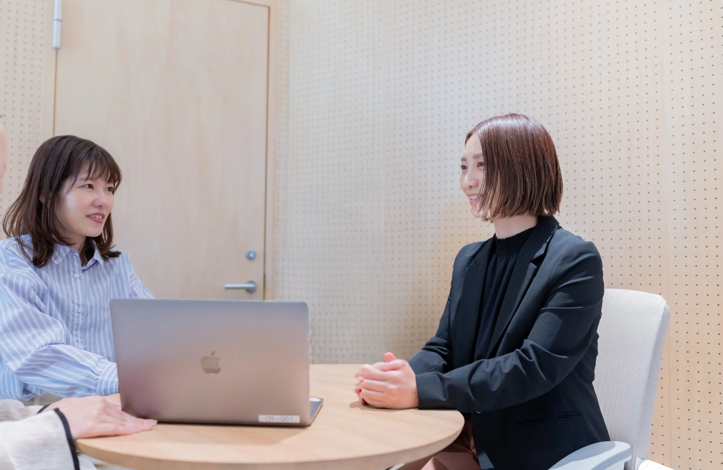 パソコンを囲んで話をする女性三人の写真